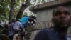 Journalists climb up a wall to take cover from gunfire, after being shot at by armed gangs at the General Hospital in Port-au-Prince, Haiti, Dec. 24, 2024.