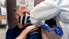 FILE - A nurse gives a volunteer firefighter an injection during a study of a possible COVID-19 vaccine developed by the National Institutes of Health and Moderna Inc., July 27, 2020.