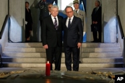 France's President Francois Hollande stands with German President Joachim Gauck in the crypt of the the National Monument of Hartmannswillerkop, in Wattwiller, eastern France, Aug. 3, 2014.