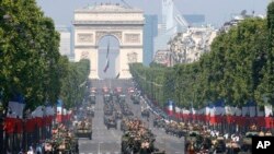 French soldiers stand in an armored vehicle during the Bastille Day parade in Paris, July 14, 2013.