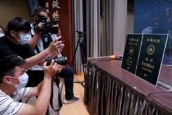Members of the media take photos of paper cut-outs of the old and new (R) Taiwan passport displayed in Taipei, Taiwan, Sept. 2, 2020.