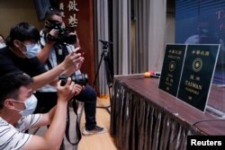 Members of the media take photos of paper cut-outs of the old and new (R) Taiwan passport displayed in Taipei, Taiwan, Sept. 2, 2020.
