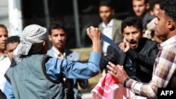 A Shi'ite Houthi rebel threatens Yemeni protesters during a rally against the control of the capital by Houthi rebels, Jan. 24, 2015.