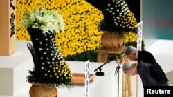 El emperador Akihito y la emperatirz Michiko se inclinan en un altar durante un momento de silencio por los muertos en la Segunda Guerra Mundial en una ceremonia con motivo del 73 anivesario de la rendición de Japón en la guerra, en Budokan Hall en Tokyo, Japón, el miércoles, 15 de agosto de 2018.