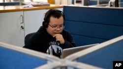 FILE - Chinese journalist Li Xin talks to an Associated Press reporter over Skype, at the Associated Press office in New Delhi, India, Nov. 20, 2015. 