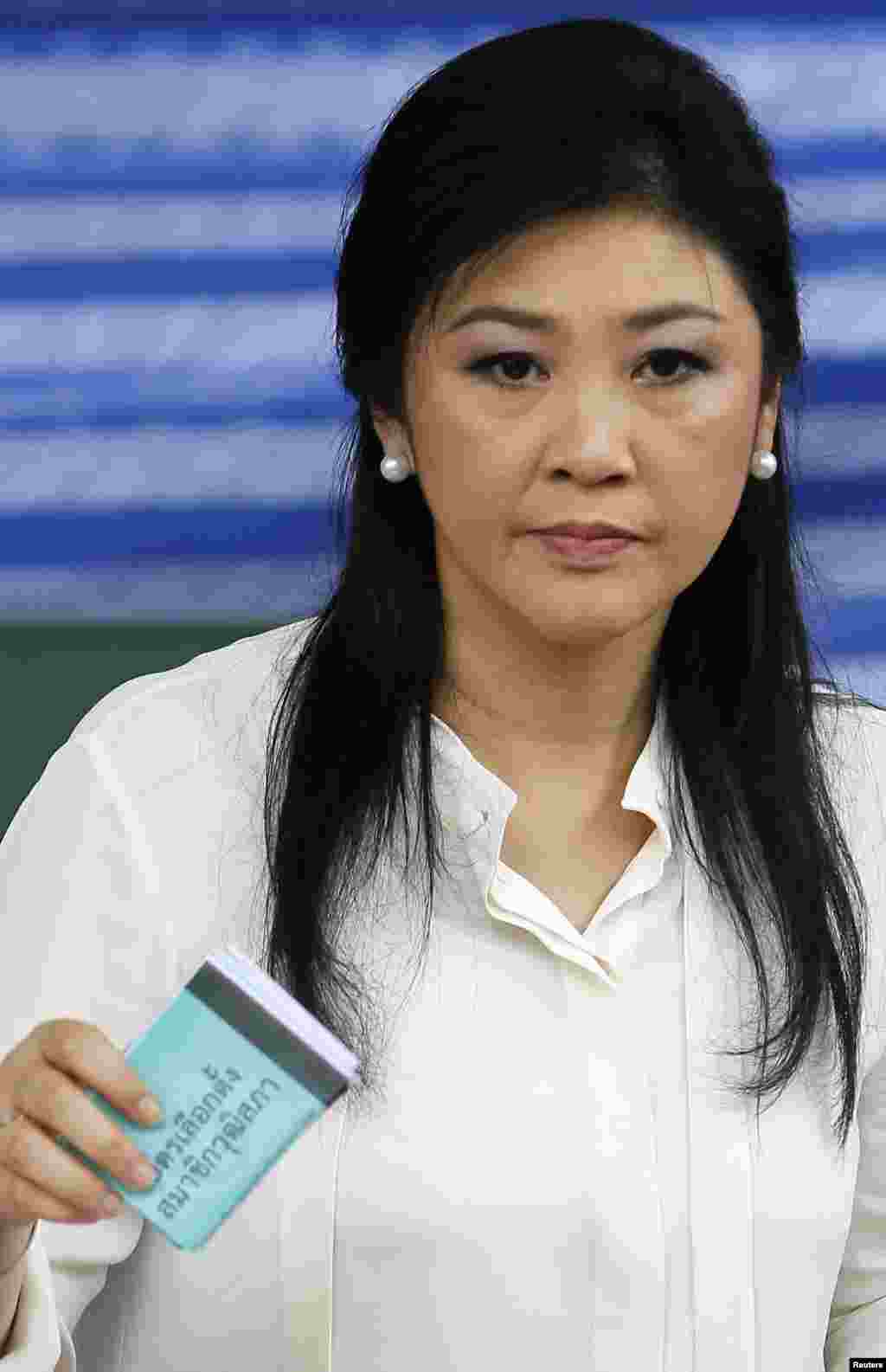 Thai Prime Minister Yingluck Shinawatra prepares to cast her ballot at a polling station in Bangkok, March 30, 2014.