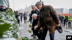 Markus Soeder, primer ministro de Baviera, el presidente alemán Frank-Walter Steinmeier y Dieter Reiter (SPD), alcalde de Munich, desde la derecha, llevan flores al lugar donde un automóvil se estrelló contra una manifestación en Munich, Alemania, el 14 de febrero de 2025. 