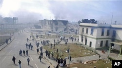 Buildings at the entrance to a security forces compound are seen burning in Benghazi on Feb 21 2011