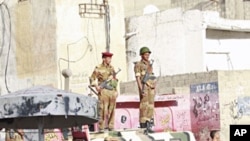 Army soldiers watch as women march during a demonstration to demand the ouster of Yemen's President Ali Abdullah Saleh in the southern city of Taiz Apr 14 2011