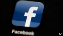 FILE - The Facebook logo is displayed on an iPad in a May 16, 2012 illustration photo. The social media giant says it is banning foreign ads related to Ireland's abortion referendum, amid concerns that North American groups are trying to influence the campaign.