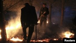 Members of the Free Syrian Army set up a fire to obscure the Kurdish militants' vision, while standing alert during a truce on top of a hilly mountain in the Kurdish area of al-Qaftal, overlooking the town of Azaz, October 31, 2012. 