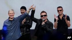 Apple CEO Tim Cook, left, with U2 members, The Edge, Bono, and Larry Mullen Jr. announce new products on Sept. 9, 2014, in Cupertino, Calif. (AP Photo/Marcio Jose Sanchez)