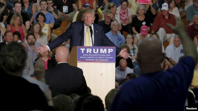 Simpatizantes de Trump levantan la mano para preguntar, durante un mitín en New Hampshire.