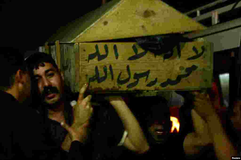 Men carry the coffin of a victim killed in one of April 15's bomb attacks, during a funeral in Najaf, Iraq. 
