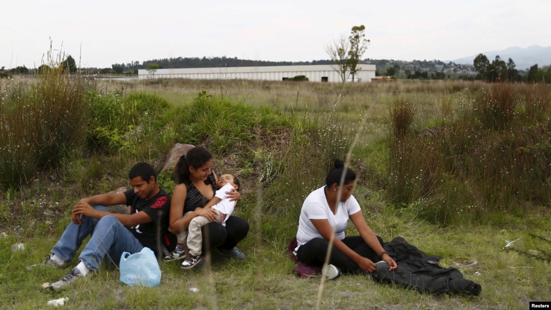FILE - A group of Central American immigrants sit between vegetation for fear of organized crime bands in Huehuetoca, near Mexico City, June 1, 2015. An increasing number of Central Americans are sneaking across Mexico's border en route to the United States.