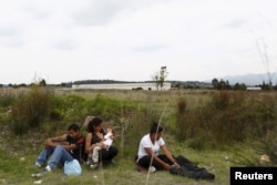 FILE - A group of Central American immigrants sit between vegetation for fear of organized crime bands in Huehuetoca, near Mexico City, June 1, 2015. An increasing number of Central Americans are sneaking across Mexico's border en route to the United States.