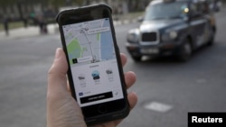 A photo illustration shows the Uber app on a mobile telephone in front of a London Taxi, in London, Britain, Nov. 10, 2017. 