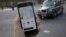 A photo illustration shows the Uber app on a mobile telephone in front of a London Taxi, in London, Britain, Nov. 10, 2017. 