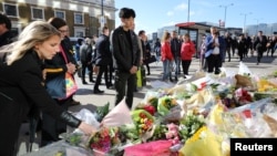 Pedestrians walk over London Bridge, and look at floral tributes, near the scene of the recent attack on London Bridge and Borough Market, London, Britain June 6, 2017.