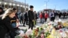 Pedestrians walk over London Bridge, and look at floral tributes, near the scene of the recent attack on London Bridge and Borough Market, London, Britain, June 6, 2017.