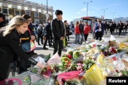 Pedestrians walk over London Bridge, and look at floral tributes, near the scene of the recent attack on London Bridge and Borough Market, London, Britain June 6, 2017.