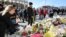 Pedestrians walk over London Bridge, and look at floral tributes, near the scene of the recent attack on London Bridge and Borough Market, London, Britain June 6, 2017.