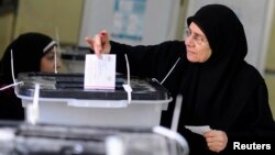 A woman casts her vote at a polling center during a referendum on Egypt's new constitution in Cairo, Jan. 14, 2014. 