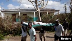 Men carry a woman wounded in Hurricane Matthew in Chantal, Haiti, Oct. 7, 2016. 