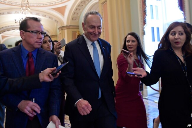 FILE - Senate Minority Leader Sen. Chuck Schumer of N.Y., is followed by reporters as he returns to Capitol Hill in Washington, Jan. 4, 2019.