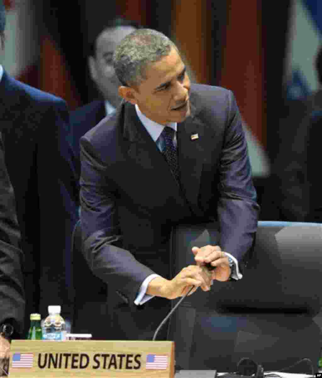 U.S. President Barack Obama covers the microphone as he arrives at the plenary session of the Nuclear Security Summit at the Coex Center in Seoul, South Korea, Tuesday, March 27, 2012. (AP Photo/Susan Walsh)