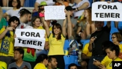 fans hold signs that read in Portuguese; "Temer Out" prior to a group E match of the women's Olympic football tournament between Brazil and Sweden at the Rio Olympic Stadium in Rio de Janeiro, Brazil, Aug. 6, 2016.