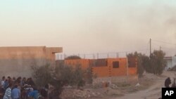 Warga setempat berlindung dari tembakan ketika pasukan keamanan Tunisia menyerbu sebuah rumah di El Aouija, pinggiran kota Ben Guerdane, dekat perbatasan Libya , Rabu (2/3).