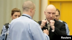 Mass killer Anders Behring Breivik has his handcuffs removed inside the court room in Skien prison, Norway, March 16, 2016. 
