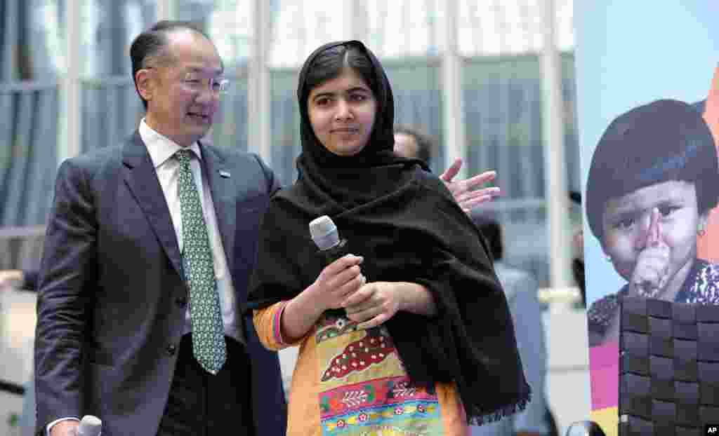 Malala Yousafzai, a menina de 16 anos que foi baleada pelos Talibãs, chega com o Presidente do Banco Mundial, Jim Yong Kim no dia Internacional da Jovem Mulher, ao Banco Mundial em Washington, Out. 11, 2013.