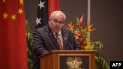 FILE - Menteri Luar Negeri Papua Nugini Justin Tkatchenko dalam konferensi pers dengan Menteri Luar Negeri China Wang Yi di Port Moresby, 20 April 2024. (Andrew KUTAN / AFP)