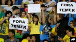 Fans hold signs that read in Portuguese "Out with Temer" prior to a women's Olympic football tournament match between Brazil and Sweden at the Olympic Stadium in Rio de Janeiro, Brazil, Aug. 6, 2016.