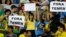 fans hold signs that read in Portuguese; "Temer Out" prior to a group E match of the women's Olympic football tournament between Brazil and Sweden at the Rio Olympic Stadium in Rio de Janeiro, Brazil, Aug. 6, 2016.
