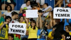 Des fans tiennent des pancartes sur lesquels on peut lire "Temer Dehors" juste avant un match entre le Brésil et la Suède aux JO de Rio, Brésil, le 6 août 2016.