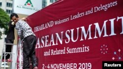 Para pekerja memasang tanda untuk menyambut para pemimpin dalam KTT ASEAN ke-35 di Bangkok, Thailand, 29 Oktober 2019.