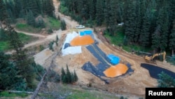 FILE - Yellow mine waste water from the Gold King Mine collects in holding pools in San Juan County, Colorado, Aug. 7, 2015. A contaminated plume of waste water accidentally released from a Colorado gold mine by U.S. environmental agency workers spread spread downstream to three states.