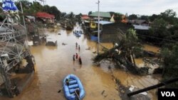 Tim penyelamat menggunakan perahu karet di kawasan banjir di kota Cagayan de Oro, Filipina selatan (17/12).