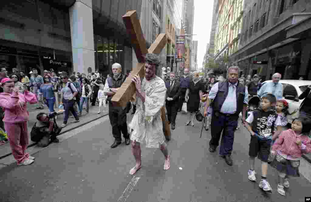 David Carnell, center, plays the part of Jesus Christ during a "Journey to the Cross" procession while celebrating Good Friday in Sydney, Australia, March 29, 2013.