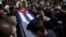 Friends and family of the late Cuban activist Oswaldo Paya carry his flag draped coffin during his burial at a cemetery in Havana, Cuba, July 24, 2012.