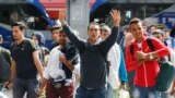 Refugees wave as they arrive at the main train station in Munich, Germany, Sept. 5, 2015. 