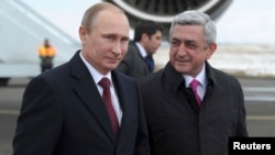 Russian President Vladimir Putin (L) walks with Armenian President Serge Sarksyan after arriving in the Armenian city of Gyumri, Dec. 2, 2013.