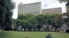 FILE: Zimbabweans rest at a park outside Meikles Hotel in central in Harare, February 24, 2015.