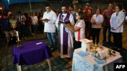 A priest gives mass nearby the Raul Brasil public school, following a shooting in which ten people -including the two shooters- died and 15 resulted injured, in Suzano, Sao Paulo metropolitan region, Brazil, on March 13, 2019.