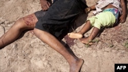 The body of a woman and her daughter lie on the ground following an overnight attack on Jon the village of Kibusu in the Tana river Delta region in Kenya, January 10, 2013.