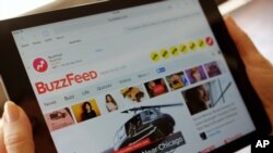 FILE - The BuzzFeed website is displayed on an iPad held by an Associated Press staffer in Los Angeles, Sept. 1, 2015. 