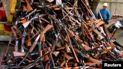 FILE - A truck unloads prohibited firearms at a scrap-metal yard that have been handed in over the past month under the Australian government's buy-back scheme in Sydney, Australia, July 29, 2017. 